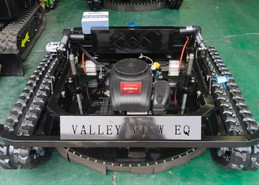 Robotic vehicle with tracks and visible branding on a green floor