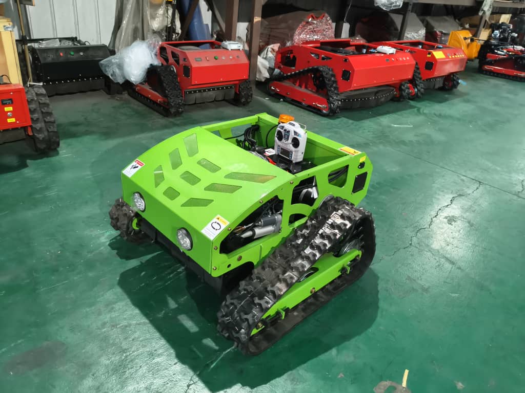 Green tracked robot on a green floor with other similar robots in the background.
