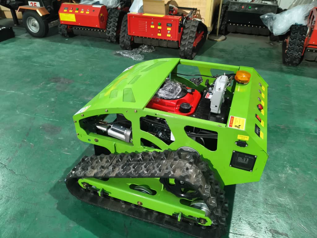 Green tracked vehicle on a green floor with other similar vehicles in the background.
