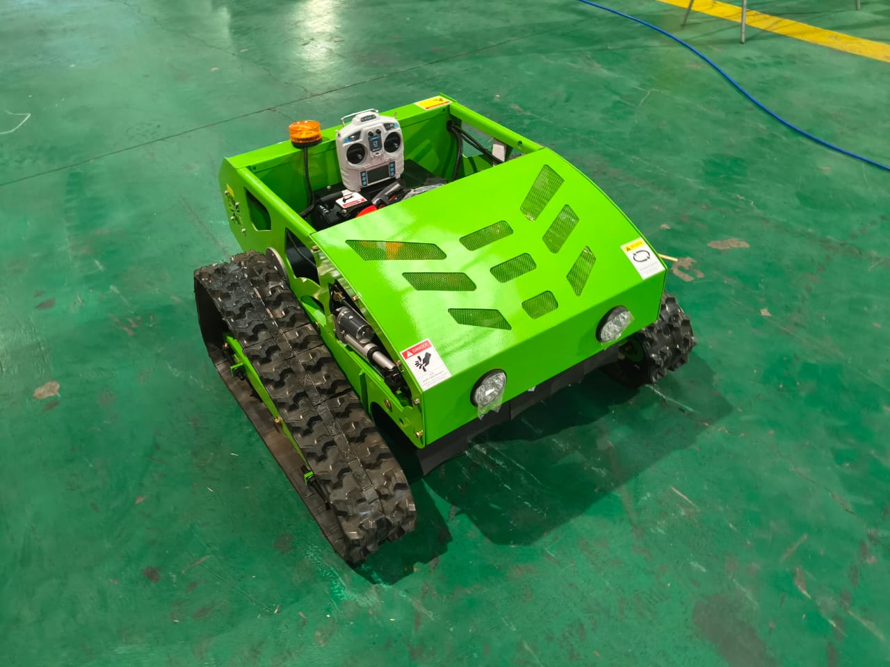 Green robot with tracks on a green floor
