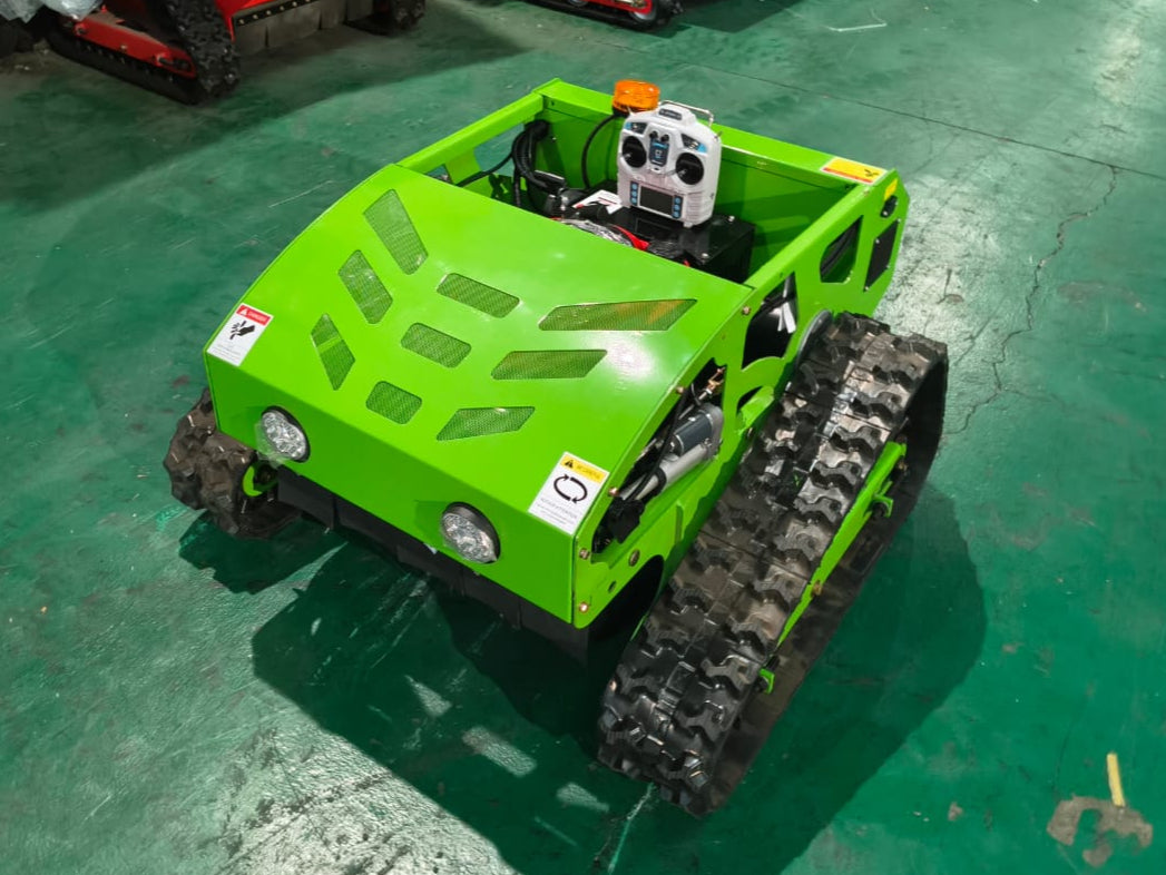 Green tracked robot on a green floor with other similar robots in the background.