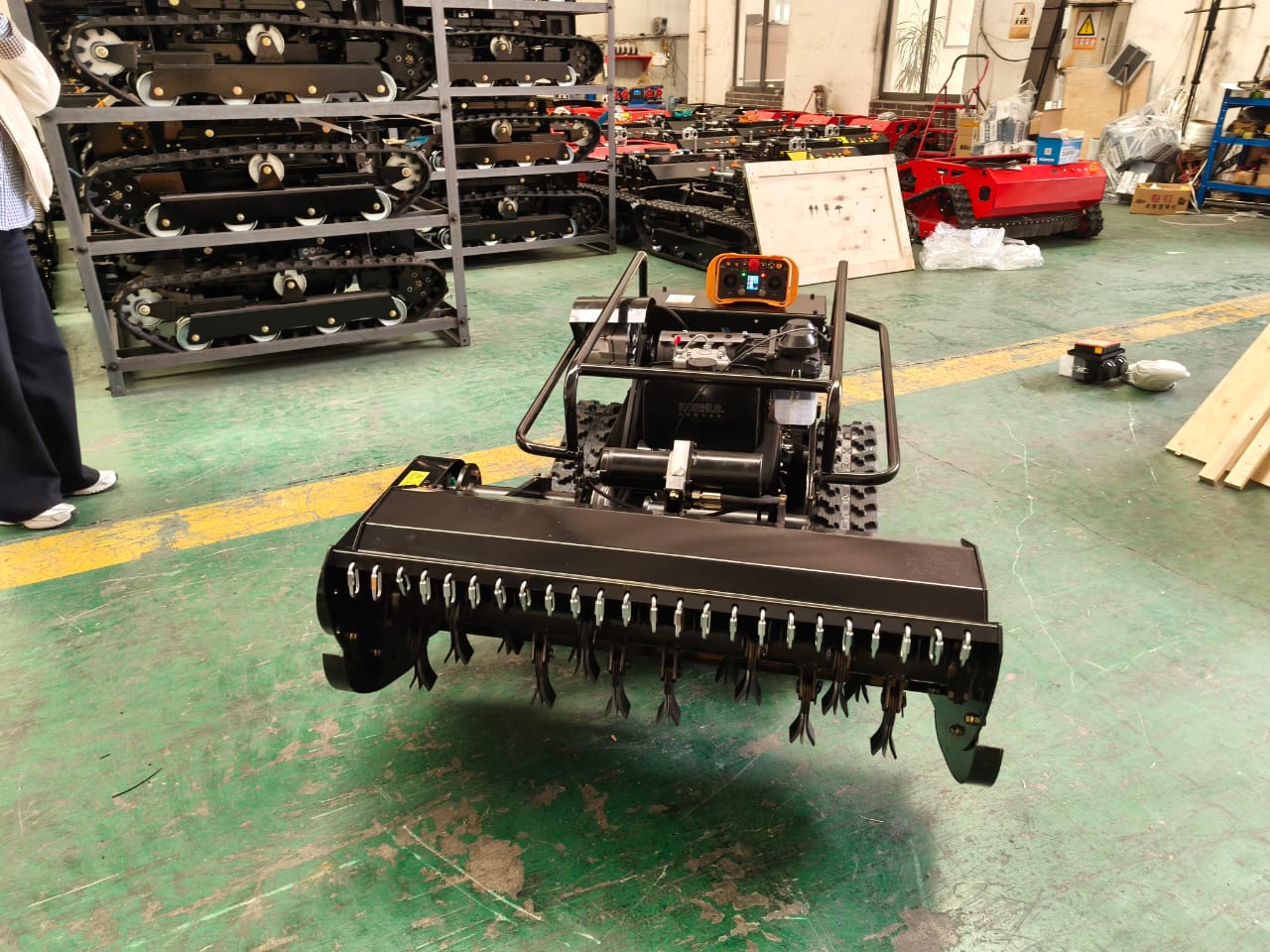 lawn mower on a factory floor with equipment and tools in the background