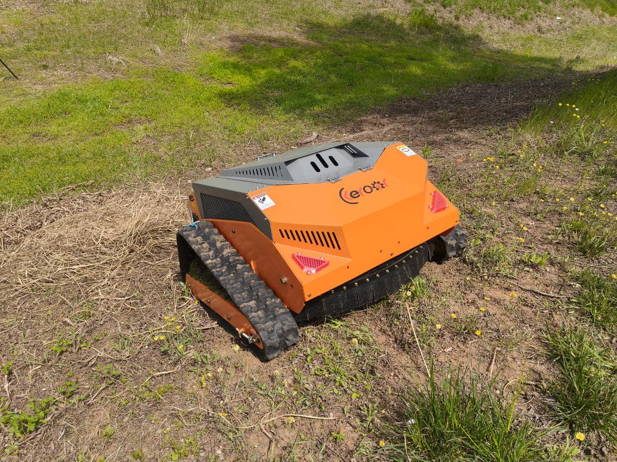 Redback remote control lawn mower with steel body and tracked slasher functionality on grassy terrain.