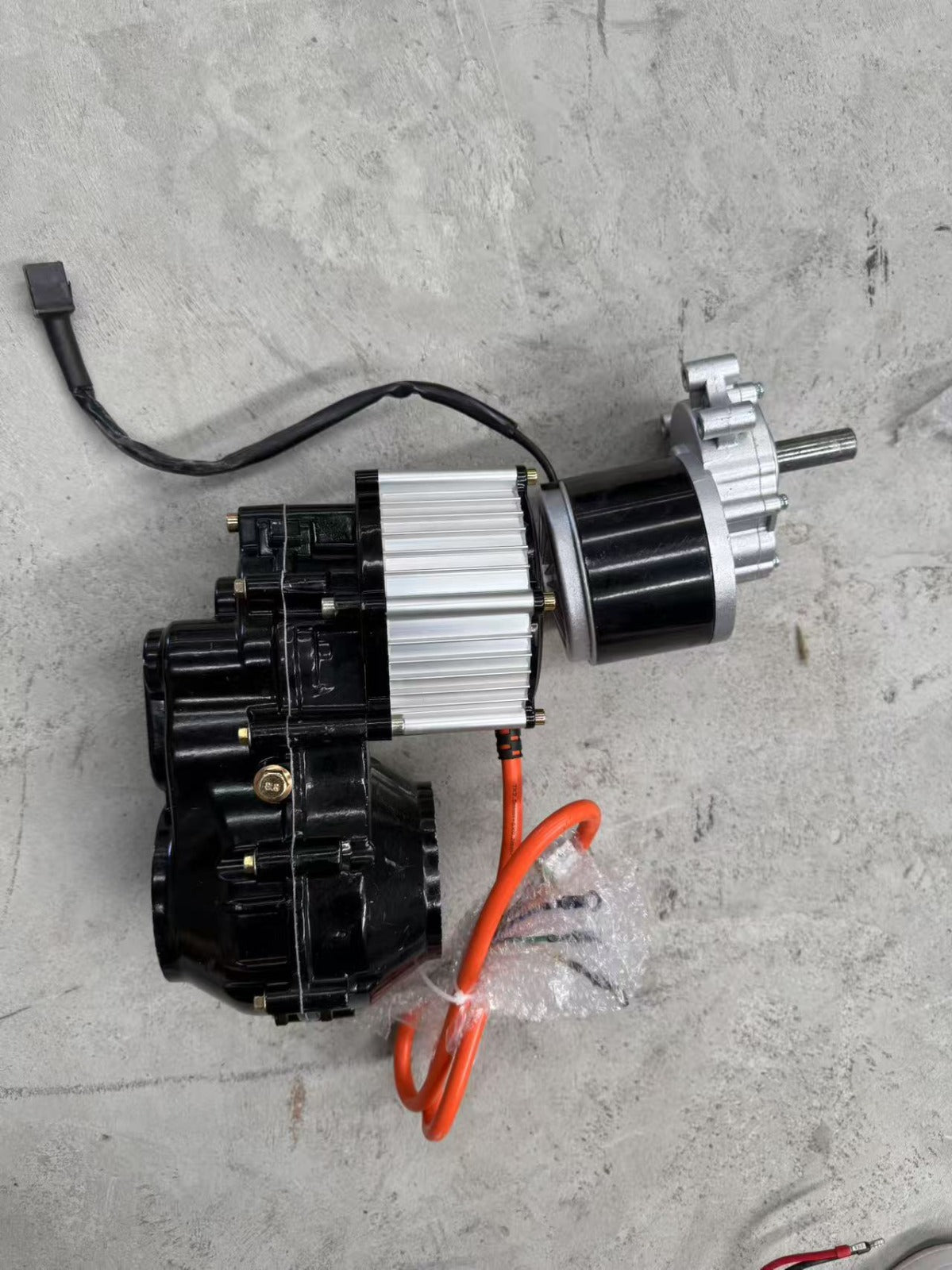 Motor and electronic components on a gray concrete surface