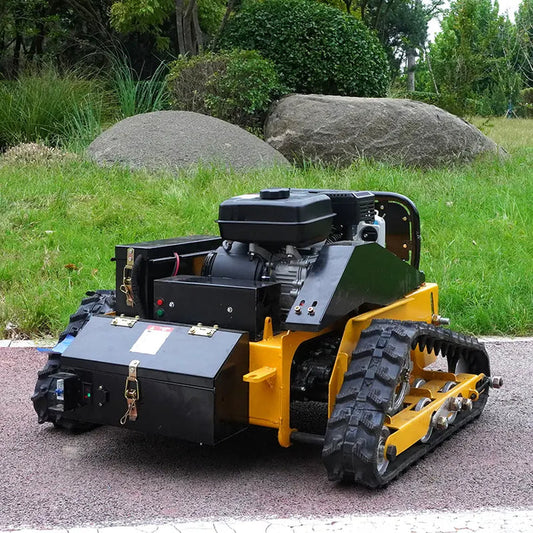Track-mounted machine on a paved surface with grass and rocks in the background